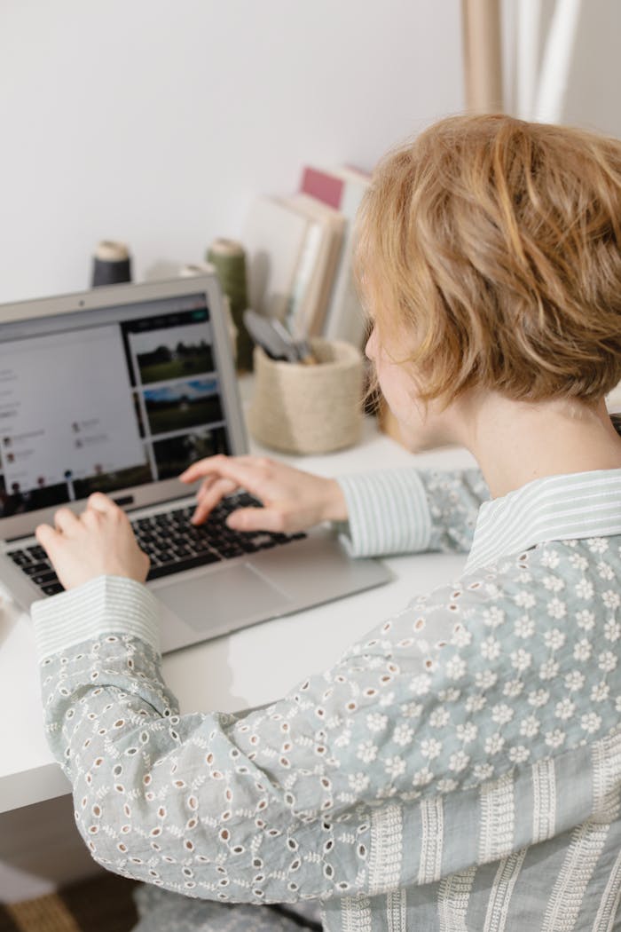 why-choose-us Woman using laptop at home desk for remote work, embodying digital nomad lifestyle.